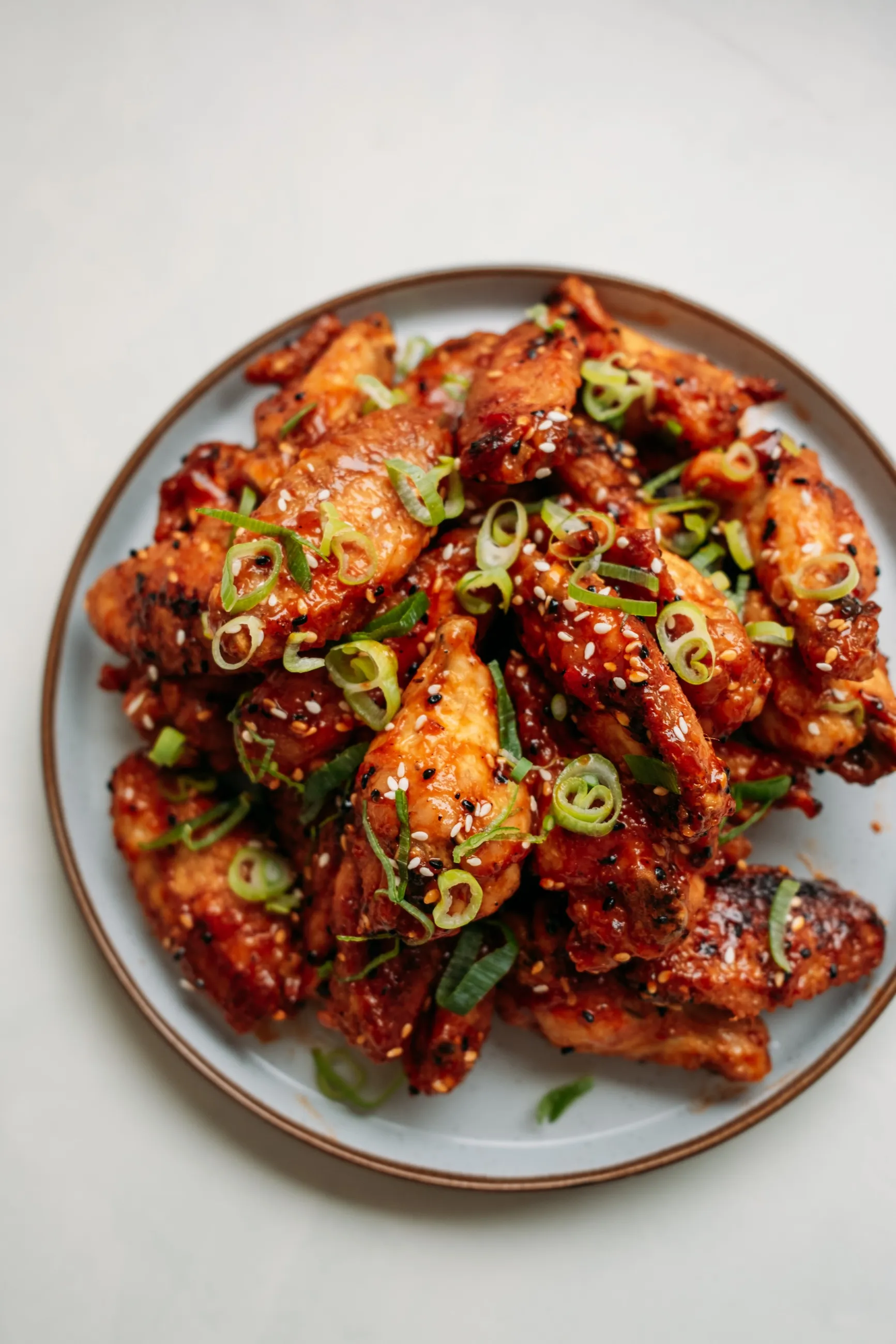 A finished dish of glazed chicken with spring onions and sesame